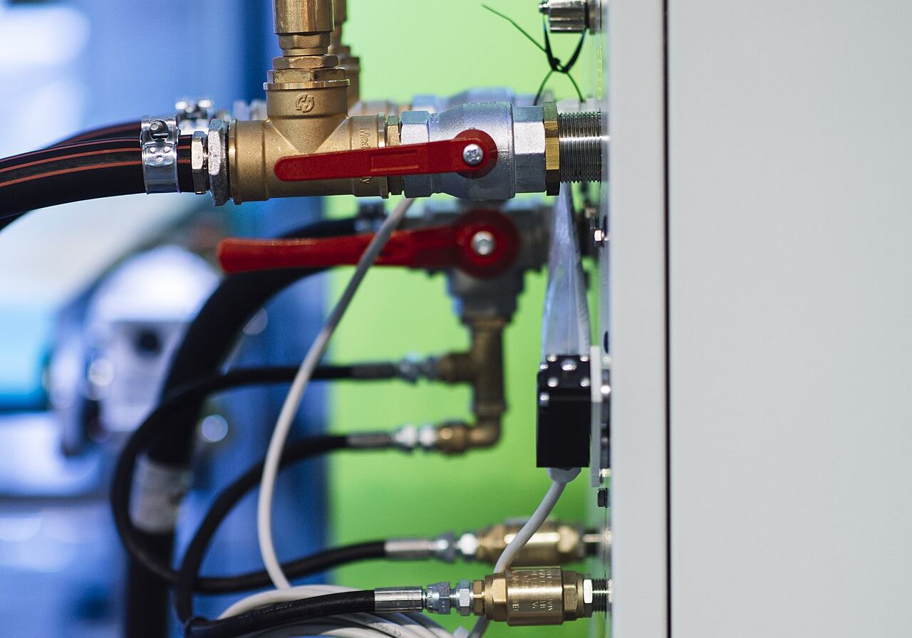 Close view of industrial pipes, valves, and fittings on process equipment